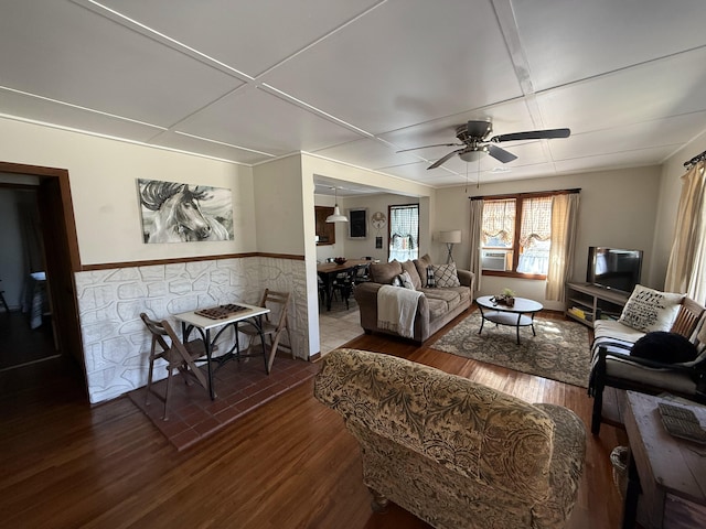 living room featuring dark wood-style floors, a wainscoted wall, and a ceiling fan