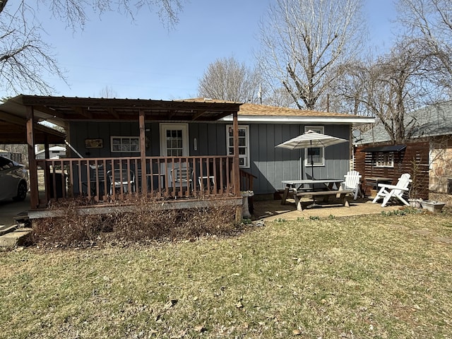 exterior space with a porch, a yard, and board and batten siding