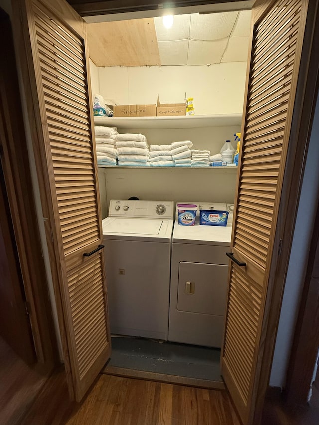 washroom with laundry area, washing machine and dryer, and dark wood-style flooring