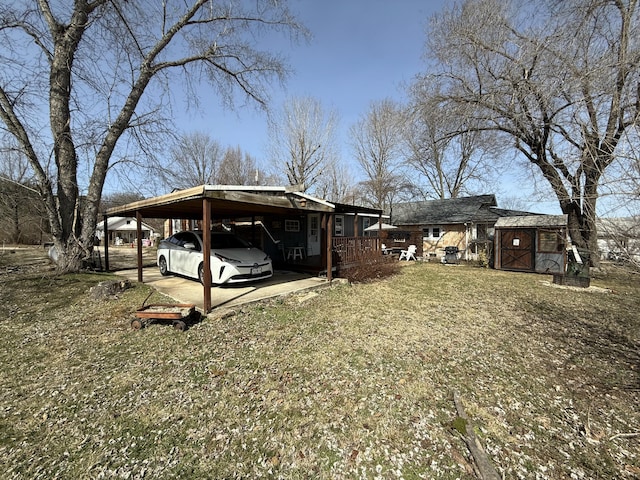 exterior space with an attached carport and an outbuilding