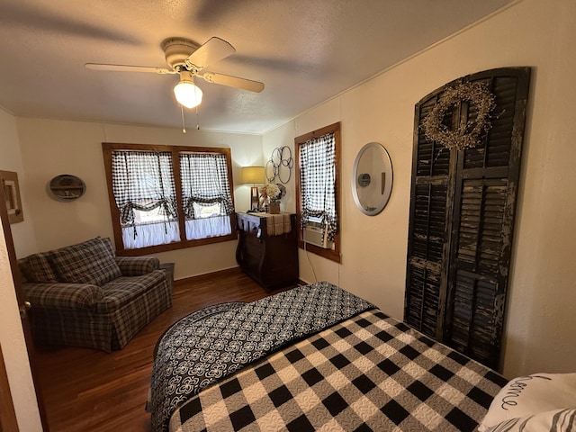 bedroom with ceiling fan, a textured ceiling, and wood finished floors