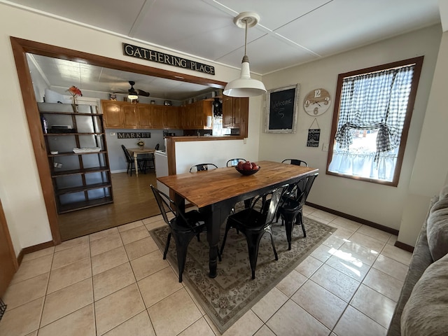 dining space with light tile patterned floors, baseboards, and ceiling fan