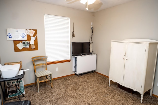 living area with a ceiling fan, baseboards, and carpet floors