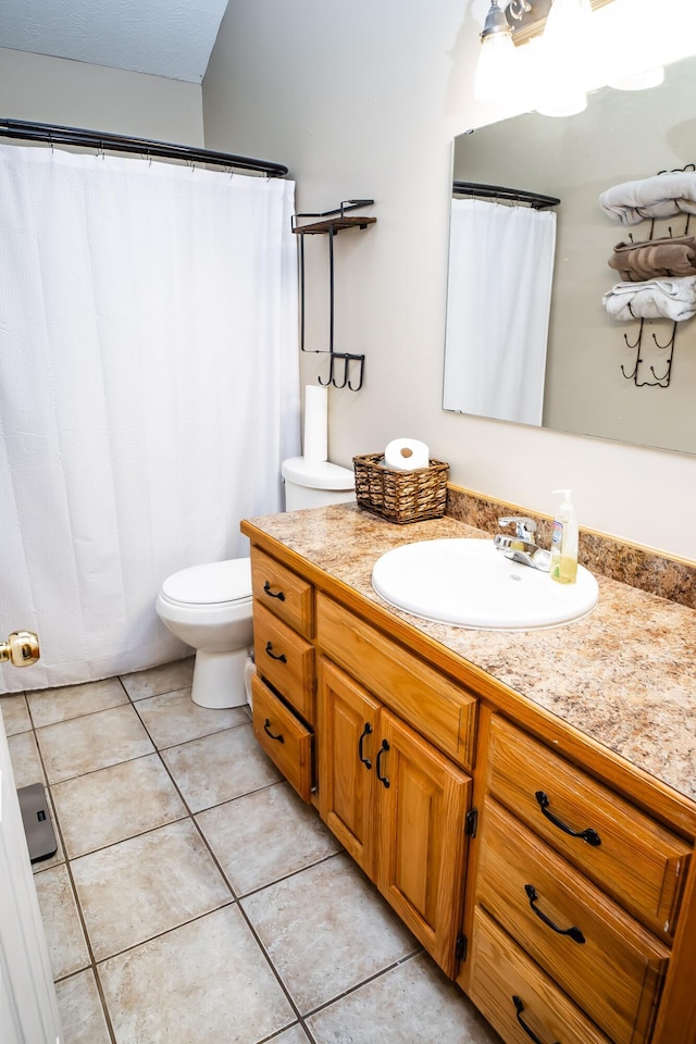 full bathroom featuring toilet, vanity, and tile patterned flooring