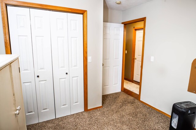 unfurnished bedroom featuring a closet, baseboards, and carpet floors