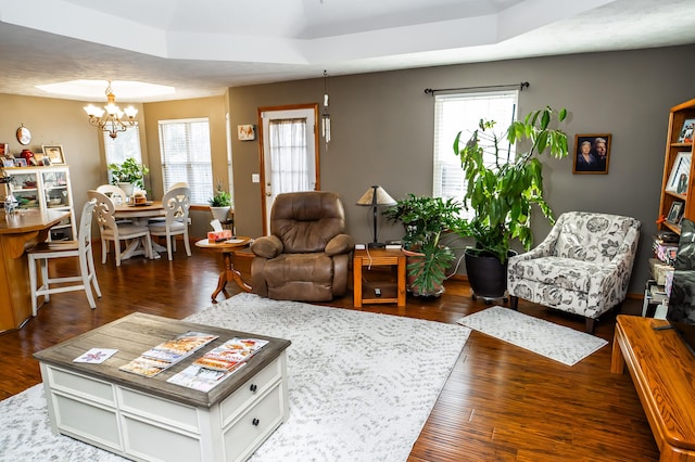 living area with a notable chandelier and dark wood finished floors