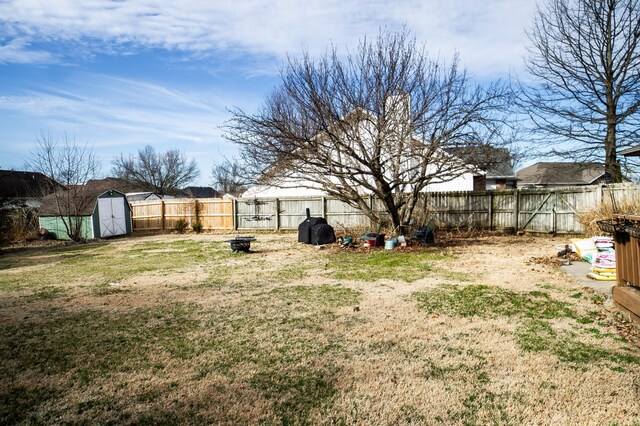 view of yard featuring an outbuilding, a storage unit, and a fenced backyard