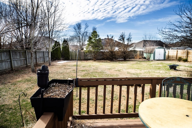 view of yard featuring a storage shed, a fenced backyard, and an outbuilding