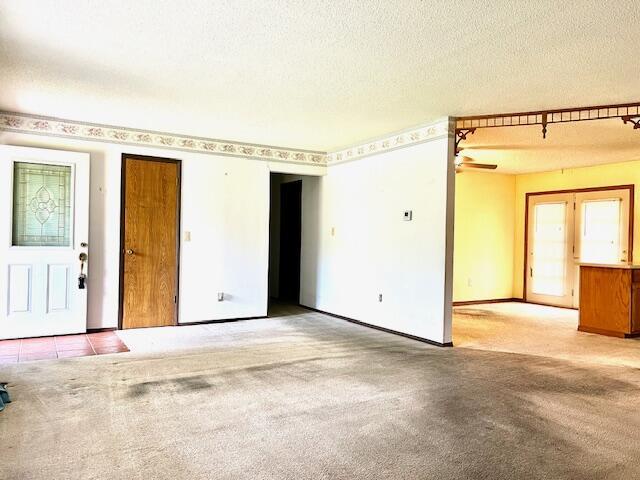 spare room featuring a textured ceiling and carpet floors