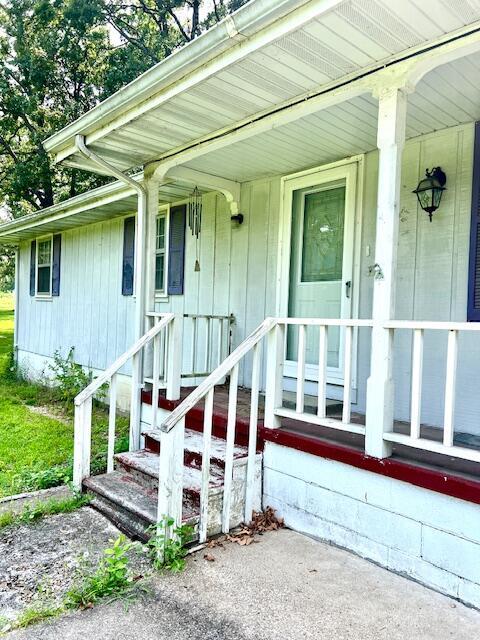 view of exterior entry with a porch