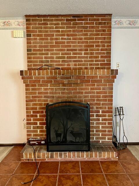 details with a fireplace, baseboards, and a textured ceiling