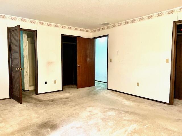 unfurnished bedroom featuring light colored carpet and baseboards