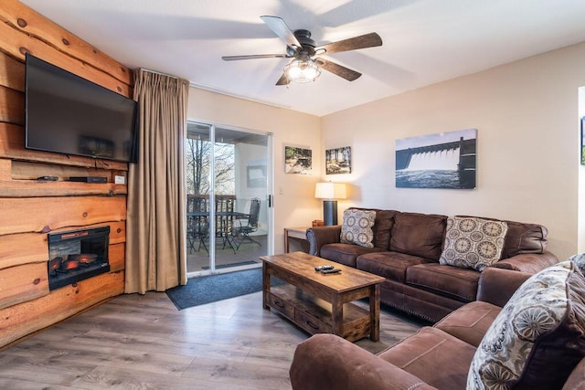 living room with a ceiling fan, wood finished floors, and a fireplace