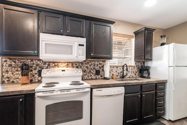 kitchen with white appliances, tasteful backsplash, and a sink