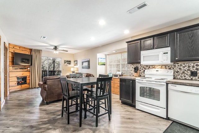 kitchen featuring decorative backsplash, white appliances, visible vents, and light wood-type flooring