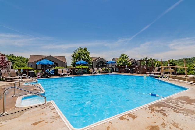 pool with a patio and fence