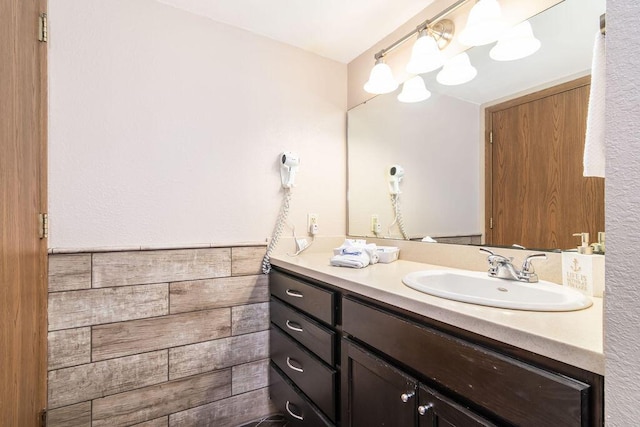 bathroom featuring vanity, tile walls, and wainscoting