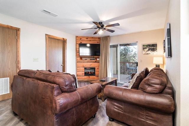 living area featuring visible vents, wood finished floors, and a fireplace