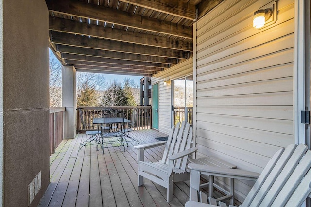 deck featuring visible vents and outdoor dining area