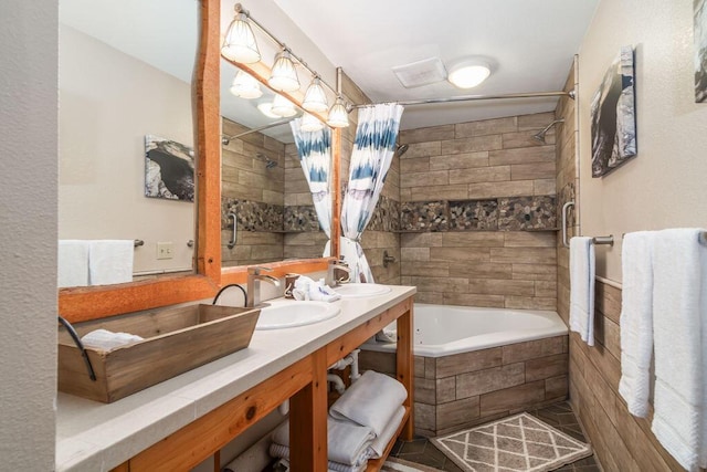 bathroom featuring a sink, tiled shower / bath, and double vanity