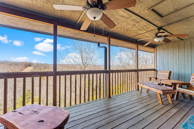 unfurnished sunroom with a ceiling fan