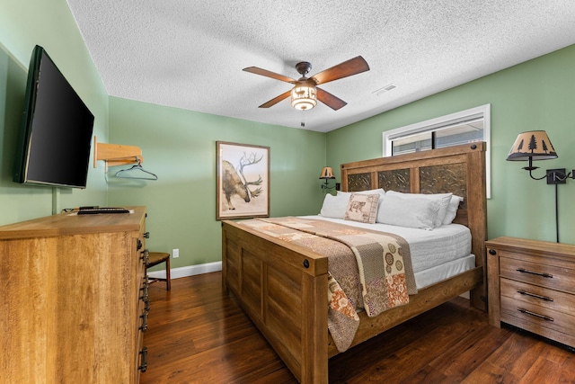 bedroom with visible vents, a textured ceiling, baseboards, and wood finished floors