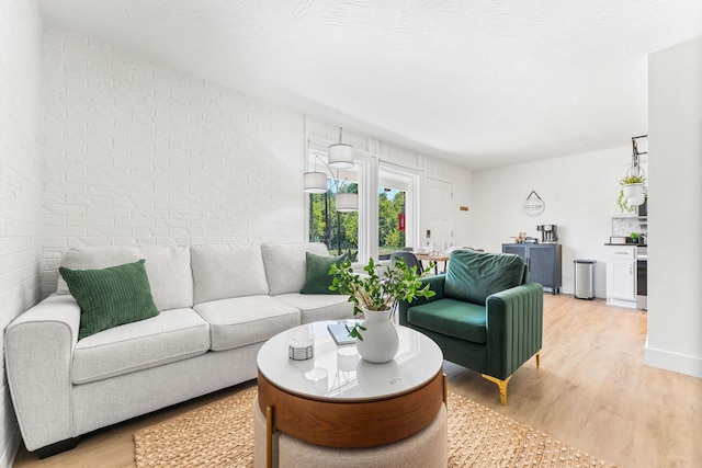 living room with brick wall and light wood finished floors