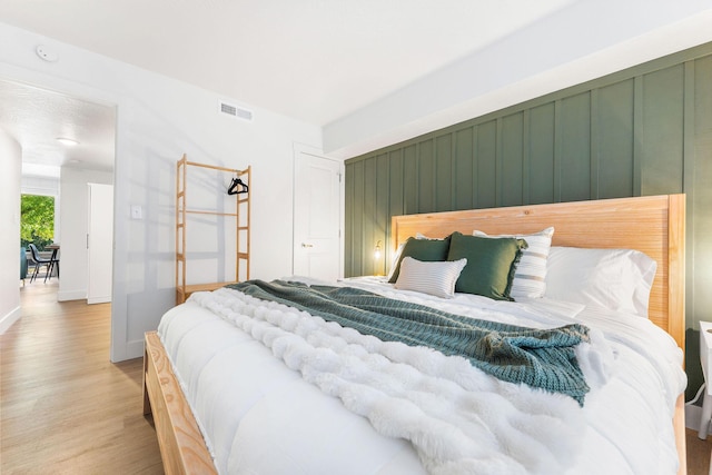 bedroom with visible vents, baseboards, and wood finished floors