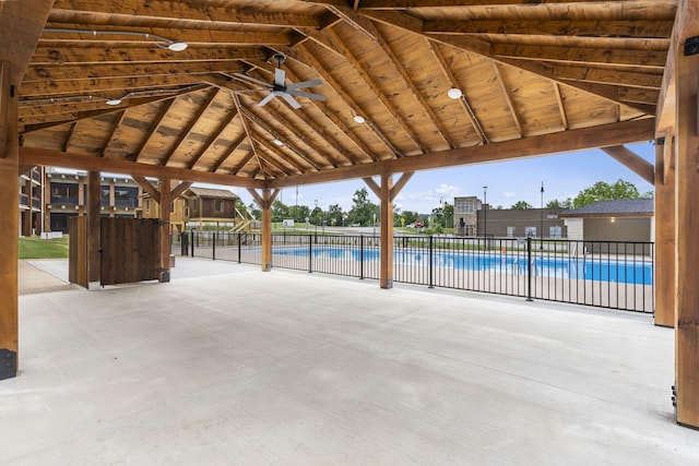 view of patio featuring a ceiling fan, a gazebo, a community pool, and fence