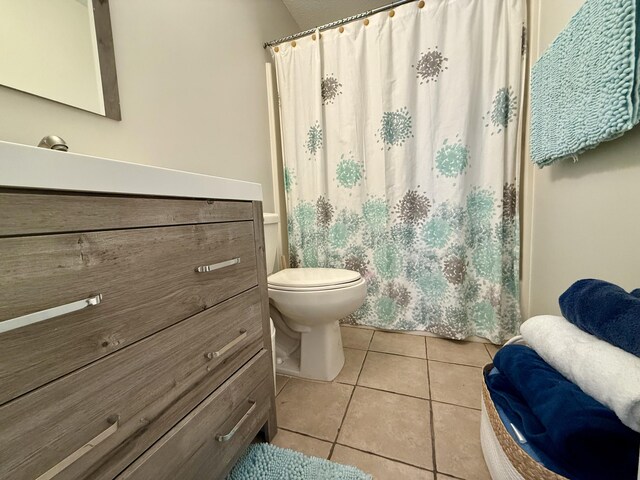 bathroom featuring curtained shower, tile patterned floors, toilet, and vanity