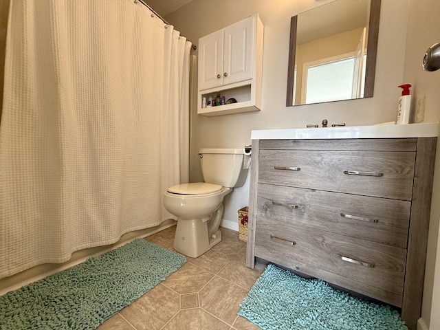 full bath featuring tile patterned floors, a shower with curtain, toilet, baseboards, and vanity