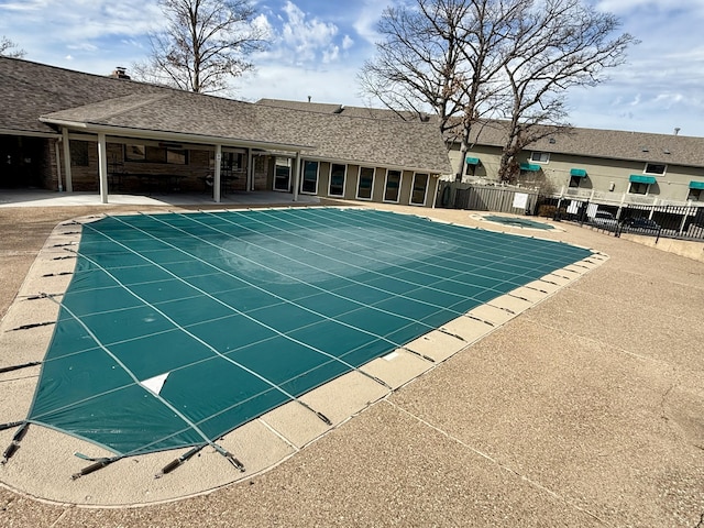 view of pool with a patio, fence, and a hot tub