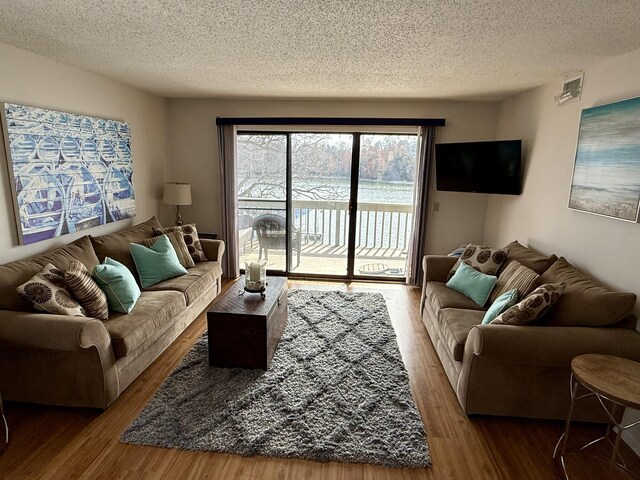 living room with a textured ceiling and wood finished floors