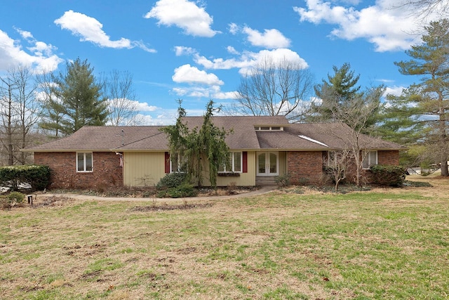 view of front facade with french doors, brick siding, and a front yard