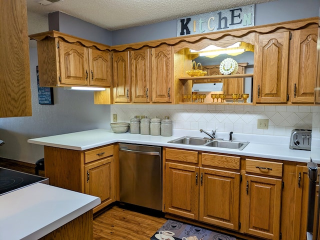 kitchen featuring dishwasher, a textured ceiling, brown cabinets, and a sink