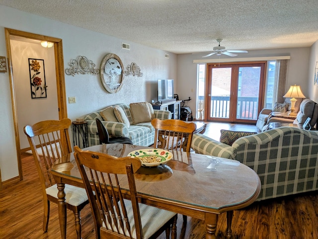 dining room featuring visible vents, a ceiling fan, a textured ceiling, wood finished floors, and baseboards