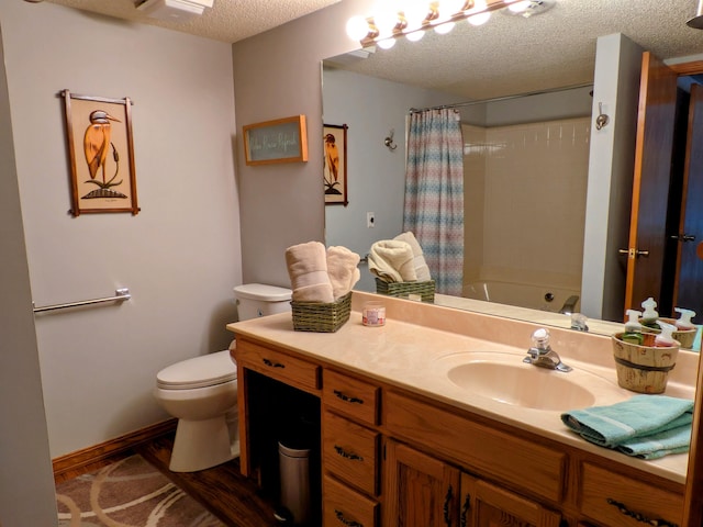 full bathroom featuring baseboards, shower / bath combo with shower curtain, toilet, vanity, and a textured ceiling