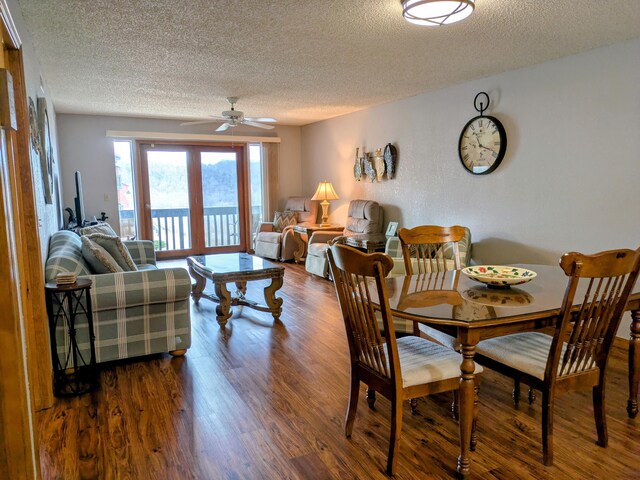 dining space featuring a ceiling fan, wood finished floors, and a textured ceiling