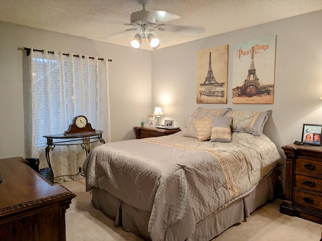 bedroom with a ceiling fan, multiple windows, light colored carpet, and a textured ceiling