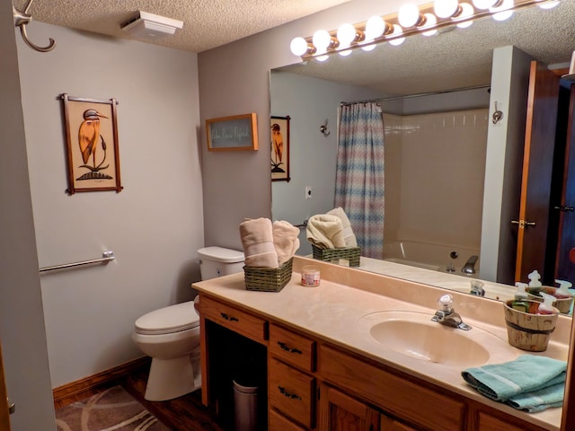 full bath featuring vanity, shower / tub combo, toilet, and a textured ceiling