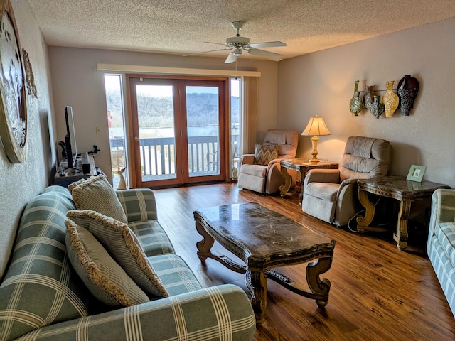 living room featuring a wealth of natural light, a ceiling fan, and wood finished floors