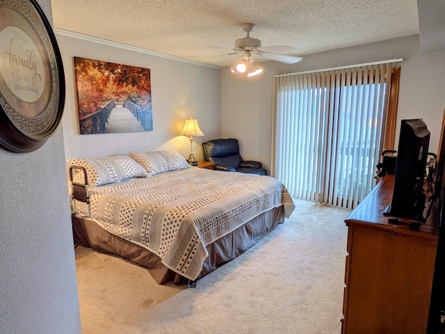 carpeted bedroom with ornamental molding, a ceiling fan, and a textured ceiling