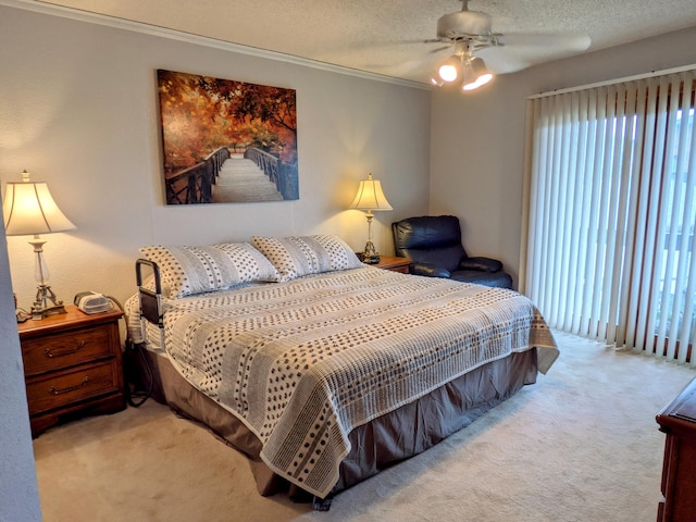 carpeted bedroom with multiple windows, a textured ceiling, ceiling fan, and ornamental molding