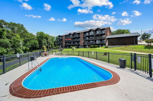 community pool featuring a yard, a patio area, and fence