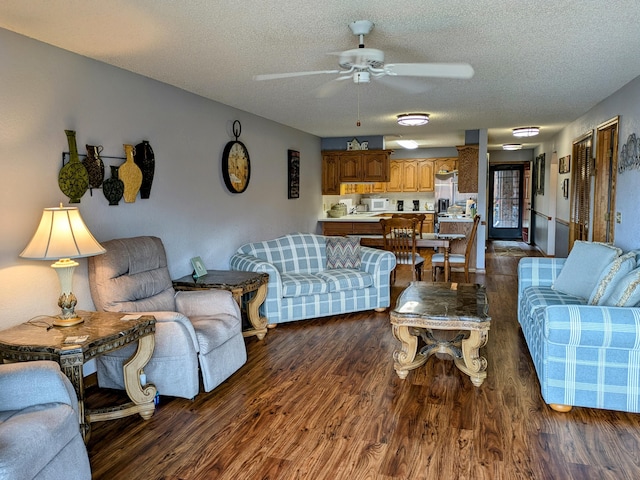 living room featuring a ceiling fan, a textured ceiling, and dark wood-style flooring