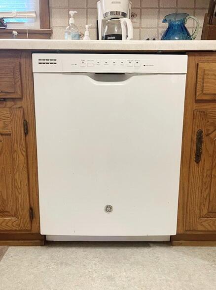 room details featuring dishwasher, tasteful backsplash, and brown cabinets