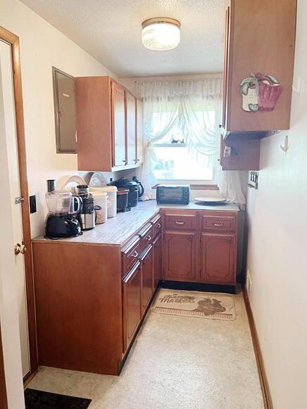 kitchen featuring light countertops, light floors, baseboards, and a textured ceiling