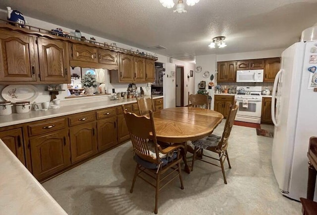 kitchen with backsplash, white appliances, a textured ceiling, and light countertops