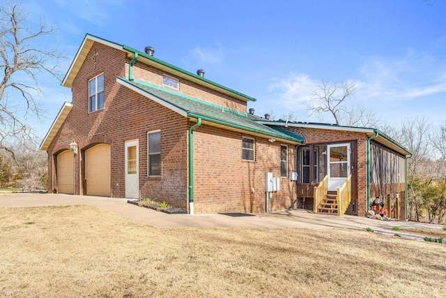 back of property featuring brick siding and driveway