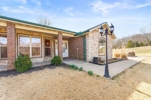 view of front facade featuring brick siding and stone siding